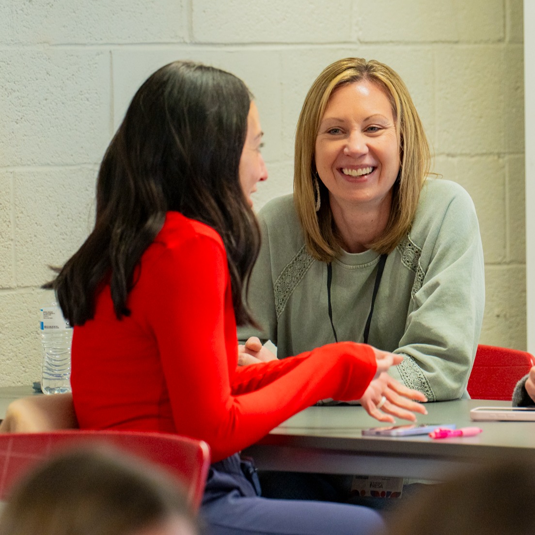 Two educators sitting at a table engaged in conversation at the countywide PD day Educate. Inform. Inspire. 2026