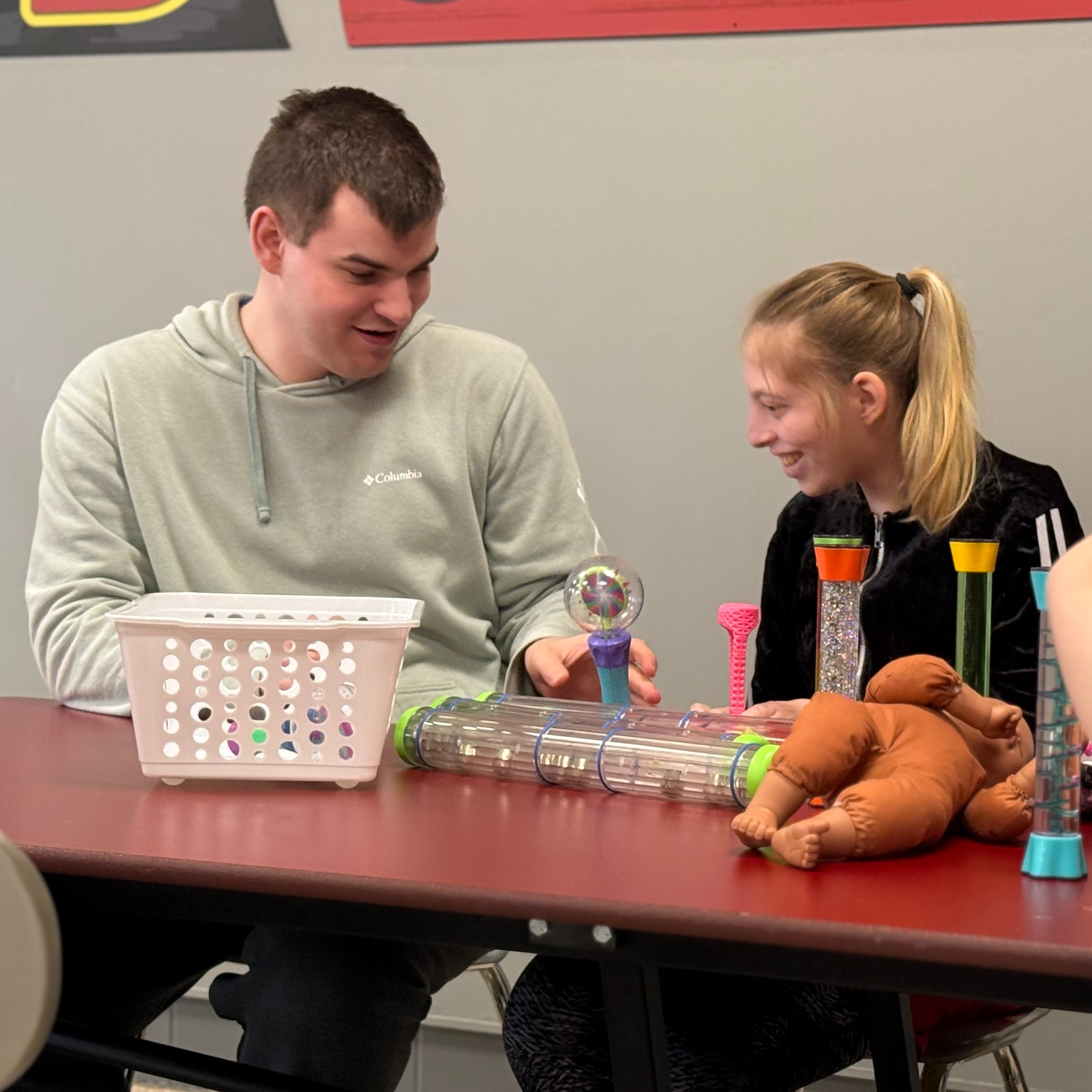 A staff member demonstrates a spinner with a Woodland student