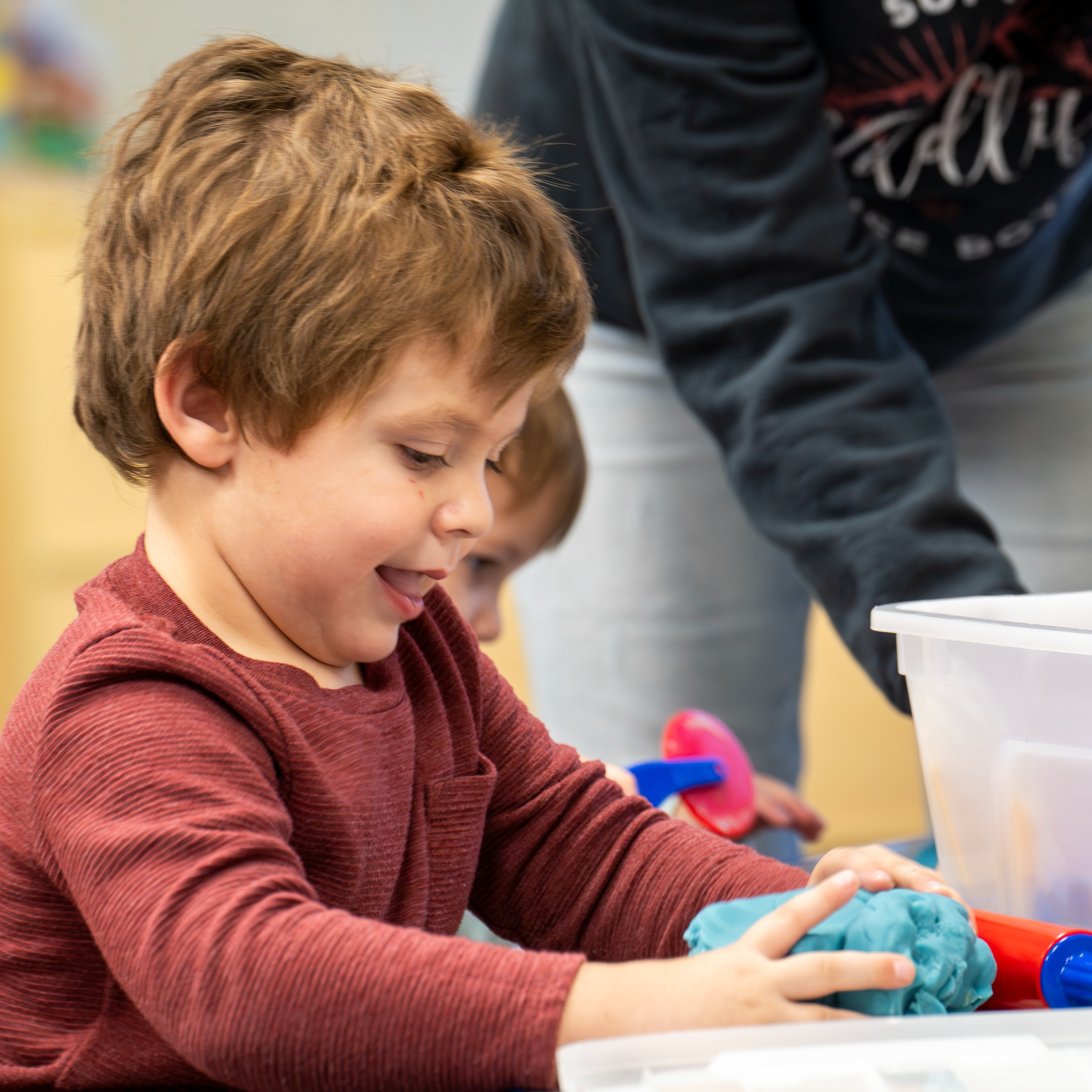 A preschooler plays with Play-Doh at a playgroup
