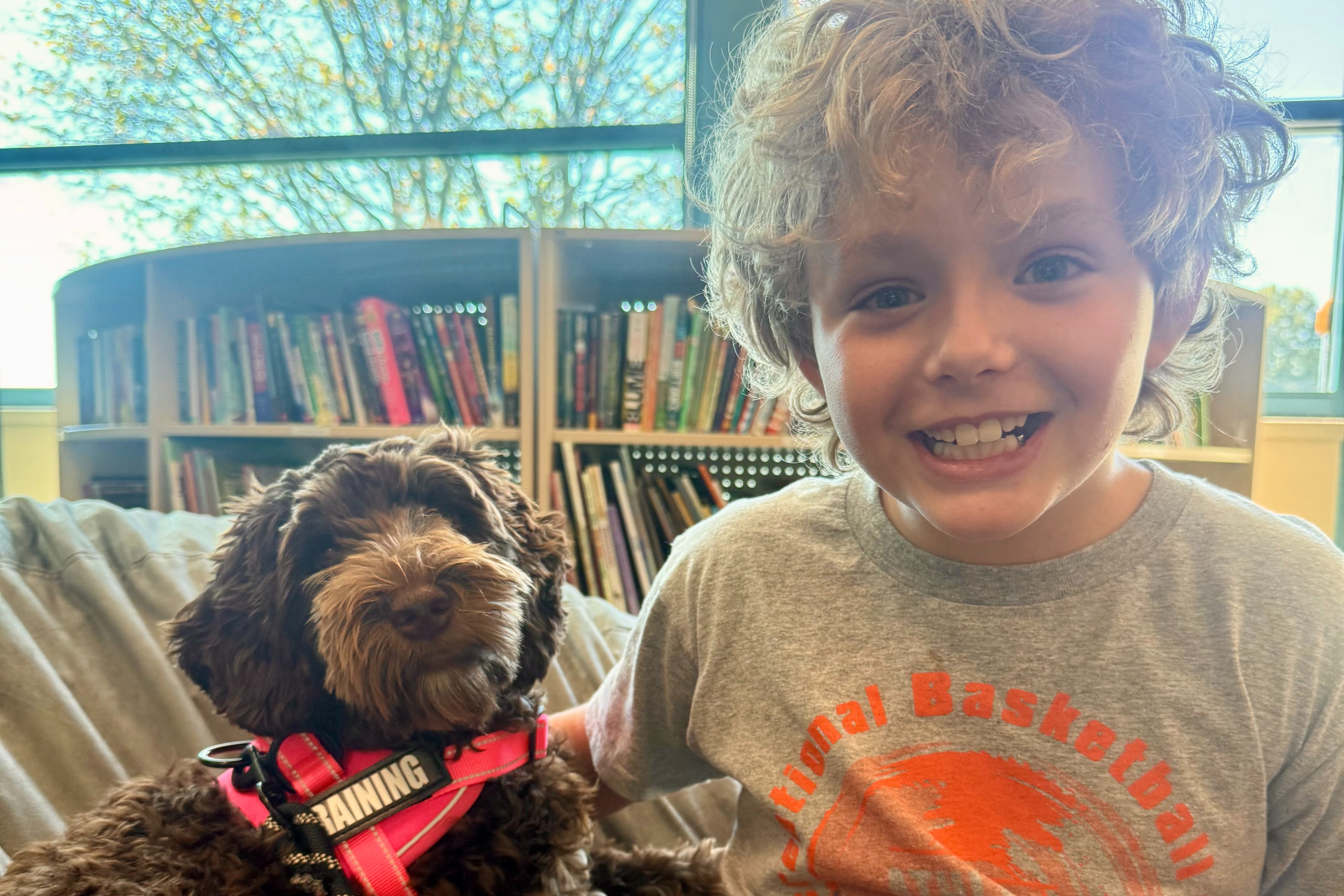 A Creekside student poses with Frannie the Therapy Dog