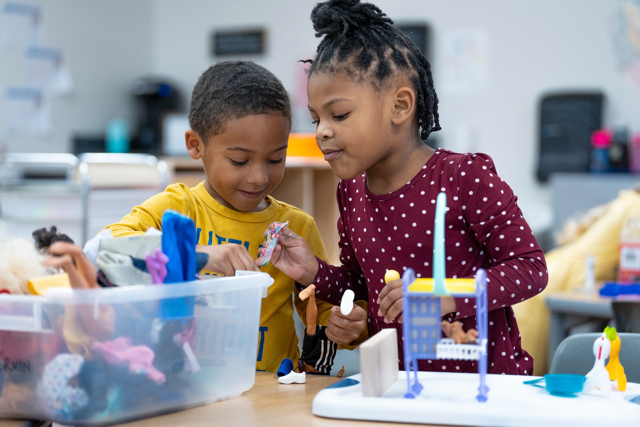 Two preschoolers play with dolls and furniture in a GSRP classroom