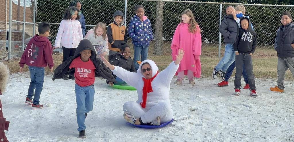 A group of children joyfully riding sleds down a snowy hill, surrounded by a winter wonderland.