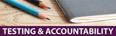 A close-up image featuring two pencils, one blue and one orange, placed on a wooden desk next to an open gray notebook. The text 'TESTING & ACCOUNTABILITY' is displayed prominently on a purple banner at the bottom.