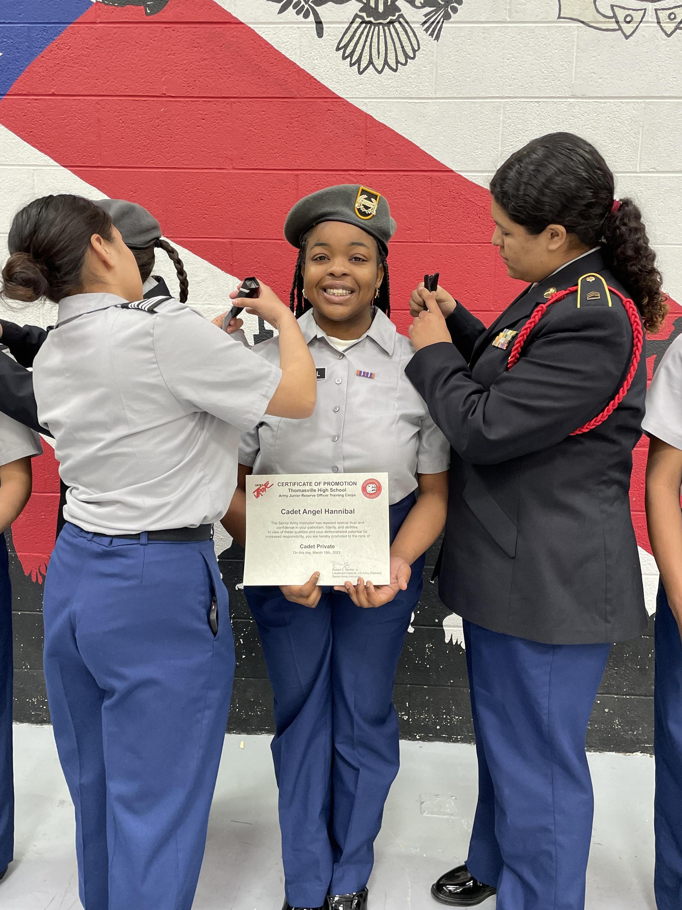 A group of women in uniform proudly displaying a certificate, showcasing their achievement and teamwork.