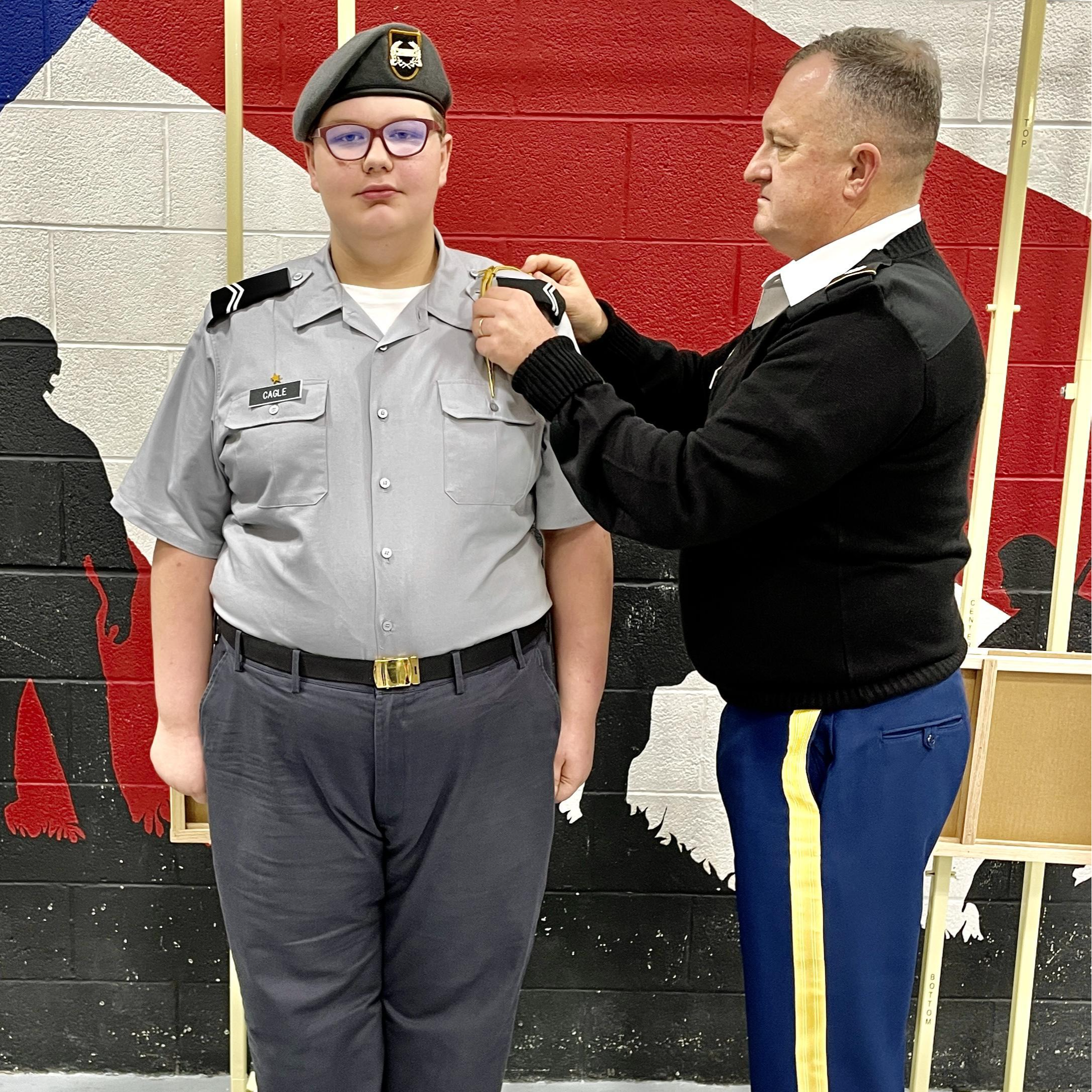 A man in uniform receives a pin on his attire, symbolizing achievement and recognition in a formal ceremony.
