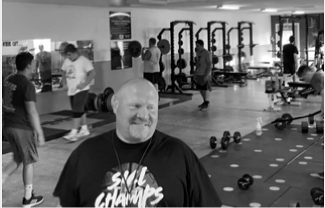 1. A man wearing a black shirt exercises in a gym, showcasing determination and focus in his workout routine. 2. A man in a black shirt engages in physical training at a gym, highlighting his commitment to fitness and health. 3. A man dressed in a black shirt works out in a gym, emphasizing his dedication to maintaining an active lifestyle.