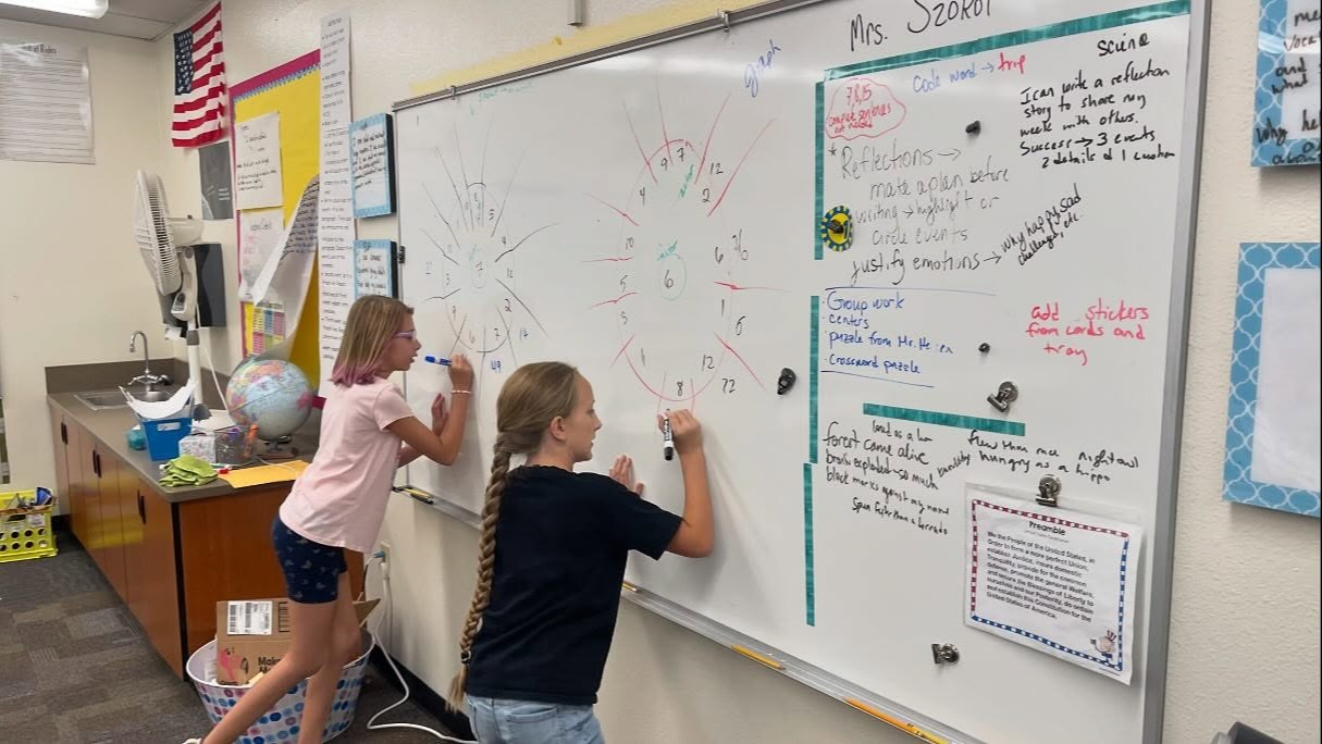 Students working on a problem on the white board