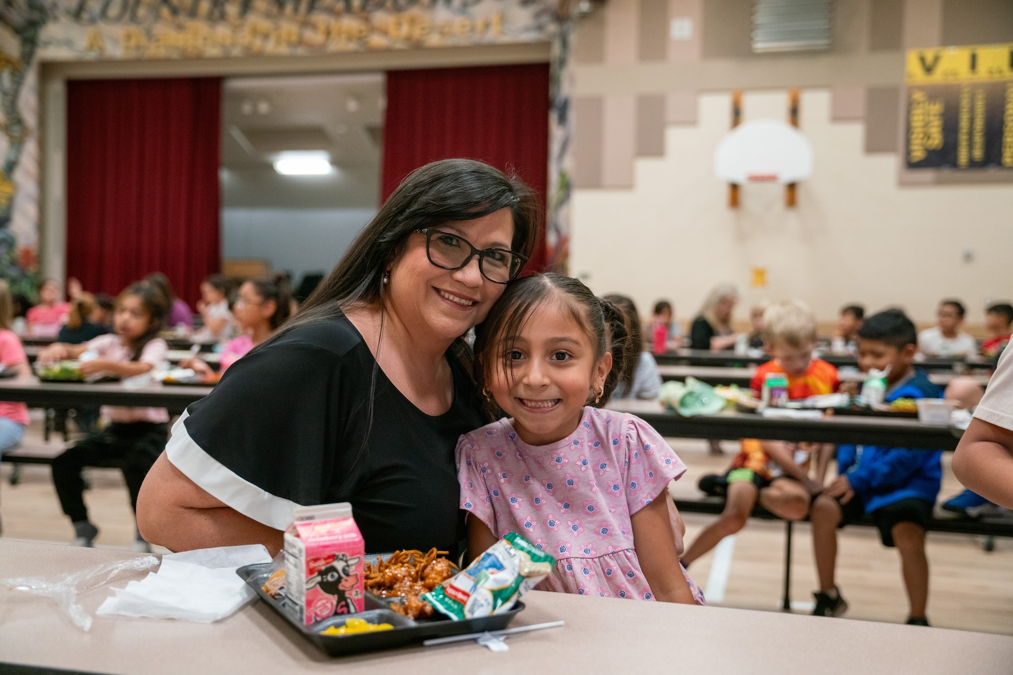 Kindergartener eating lunch with mom