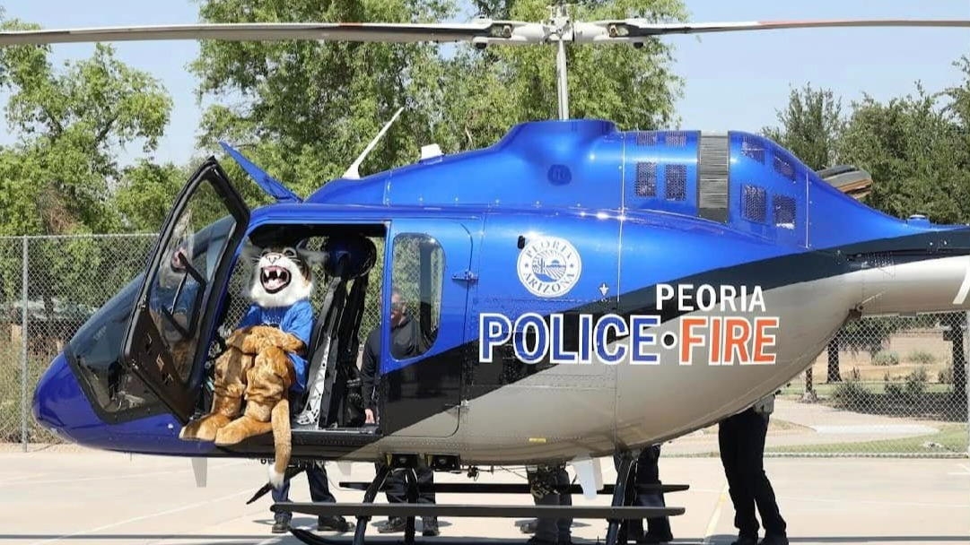 Mascot sitting in Peoria Police & Fire helicopter