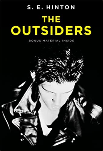 The cover of 'The Outsiders' by S. E. Hinton features a black and white image of a young man with slicked-back hair, looking down, against a black background with bold yellow text.