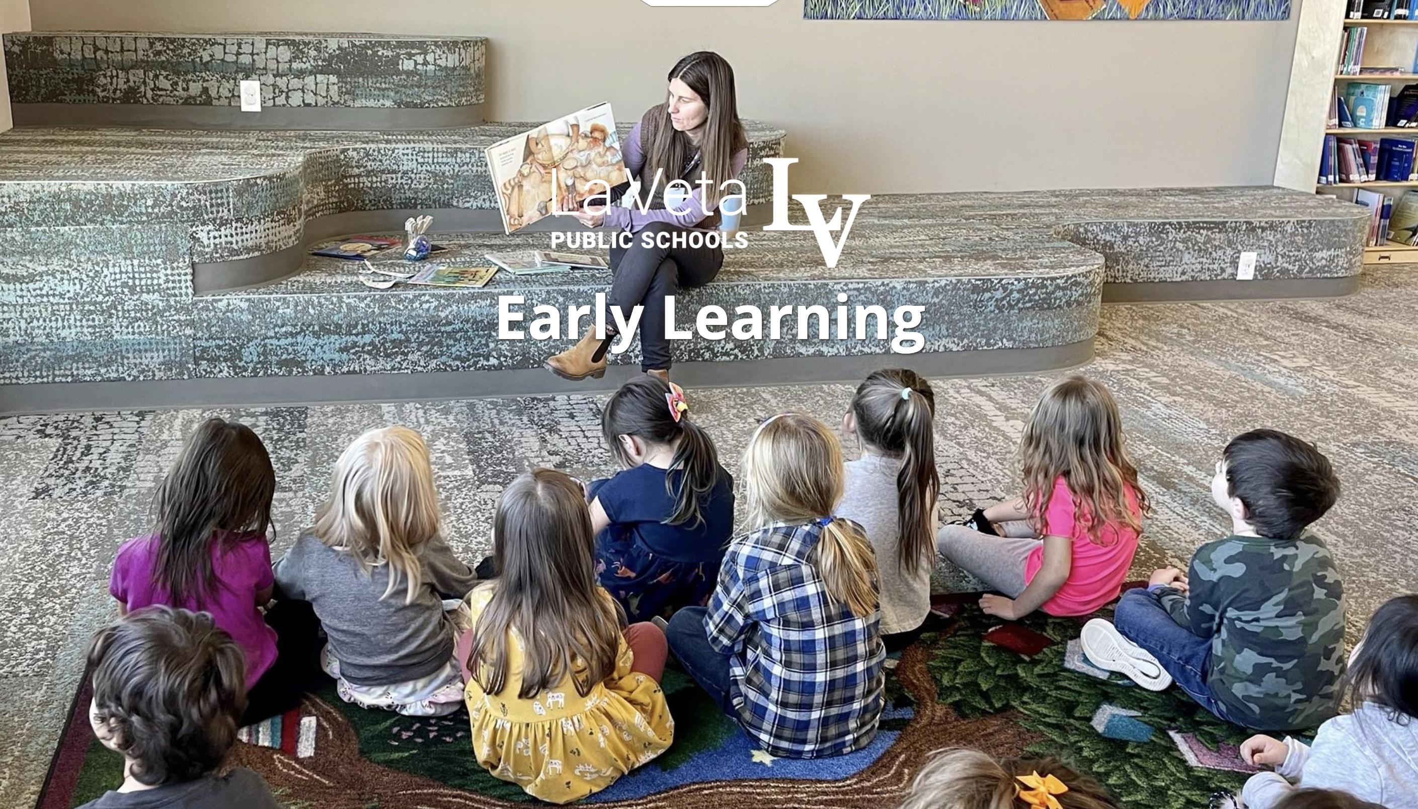 Teacher reading a book to a group of kids