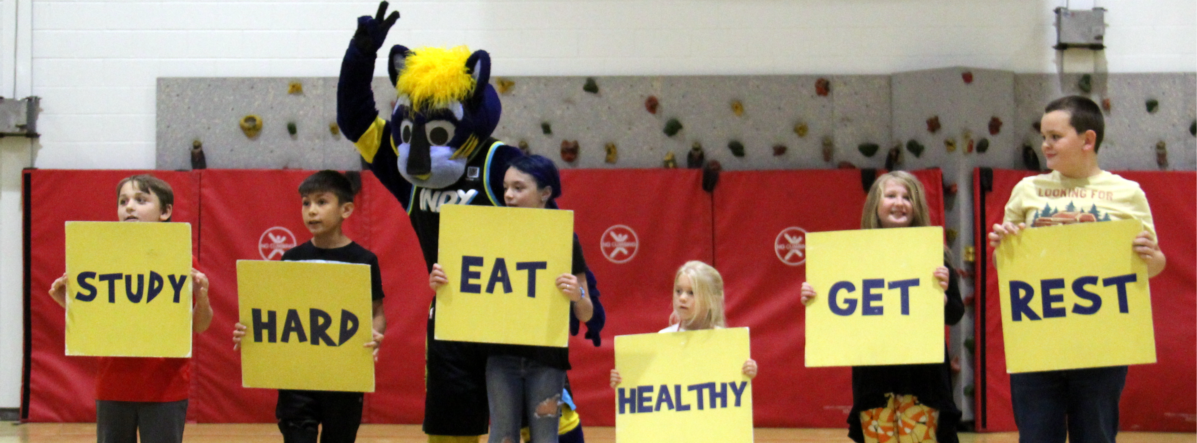 students holding signs for Pacers mascot Boomer