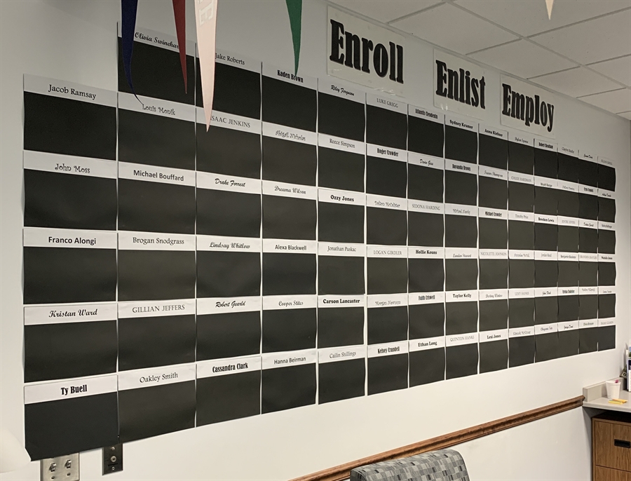 A large black board displaying a variety of names written in different styles and sizes.