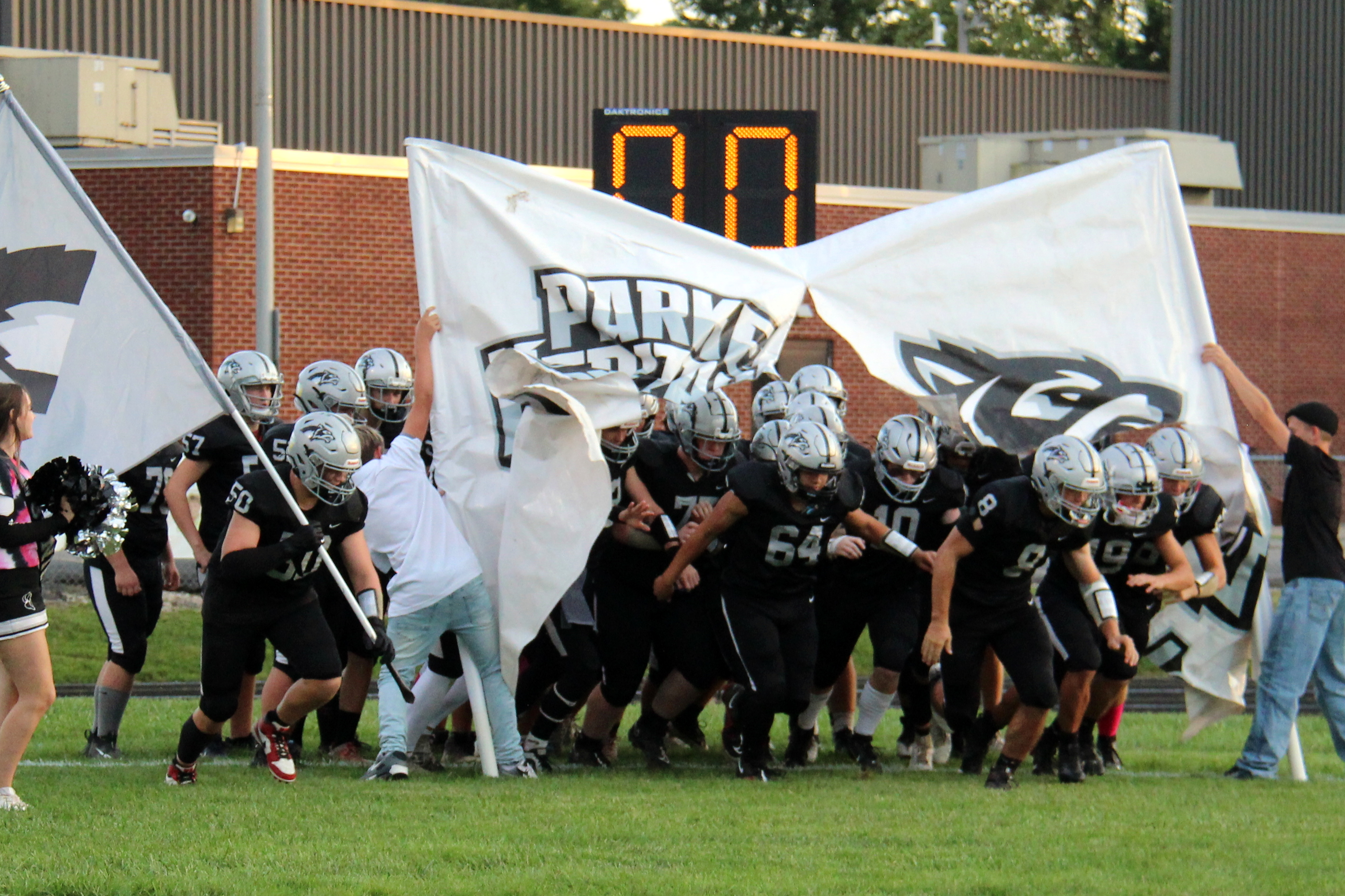 football players going through the banner