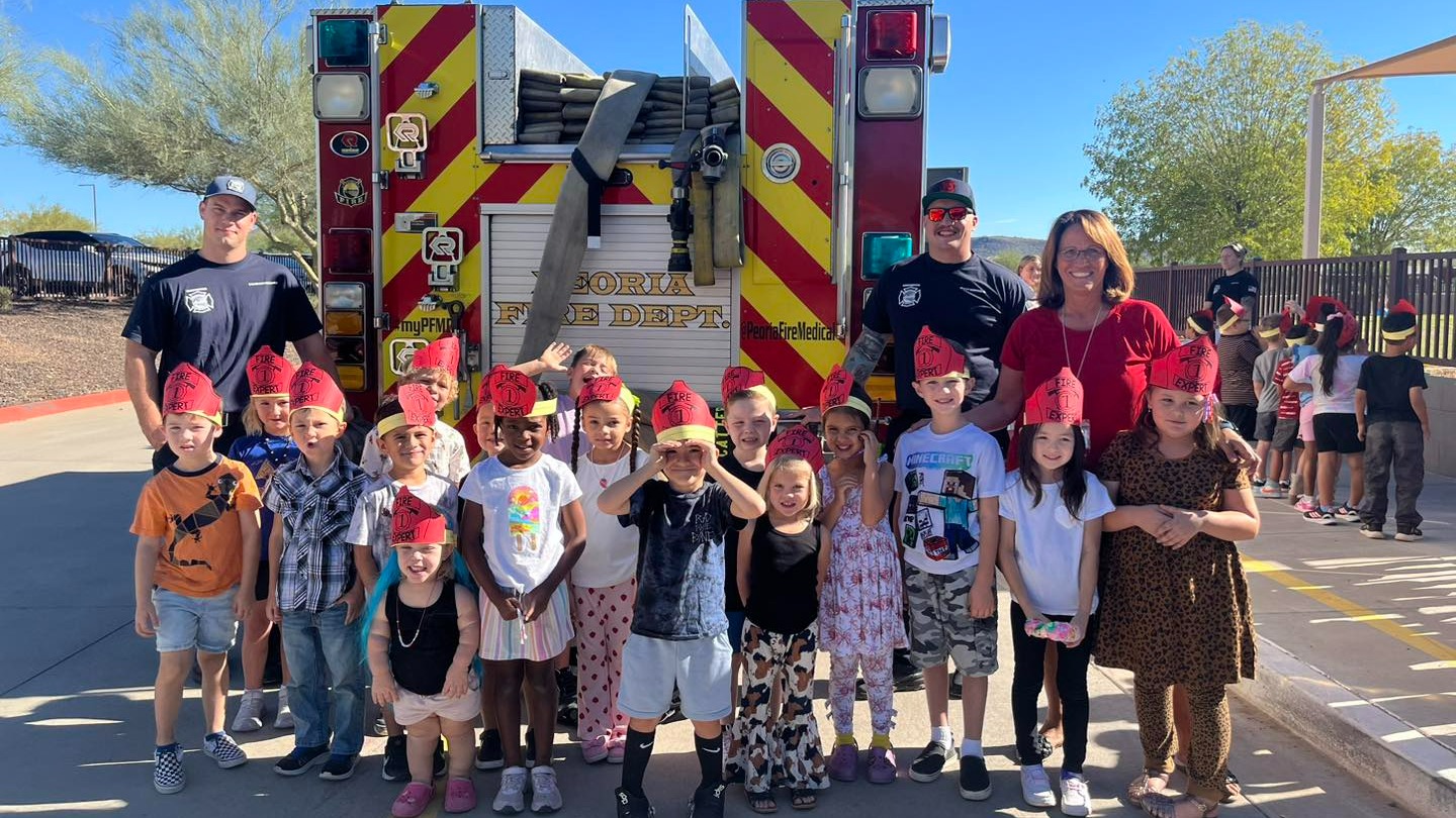 Students behind a City of Peoria fire truck