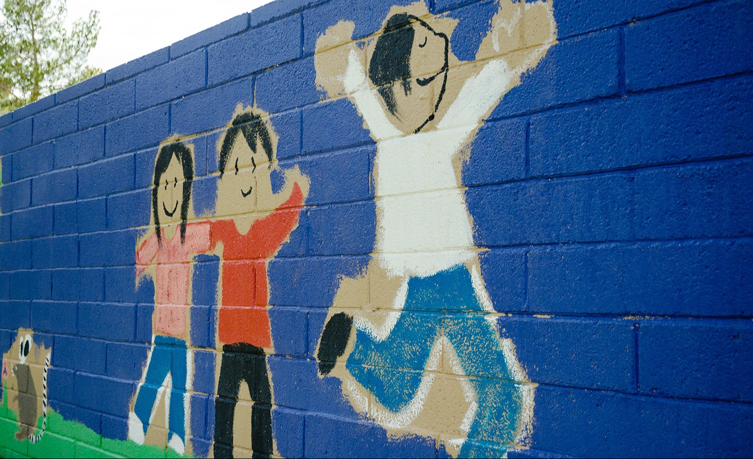 painting of children on brick wall