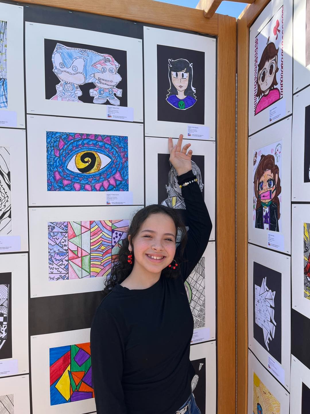 Student showing off artwork at the Arts Festival
