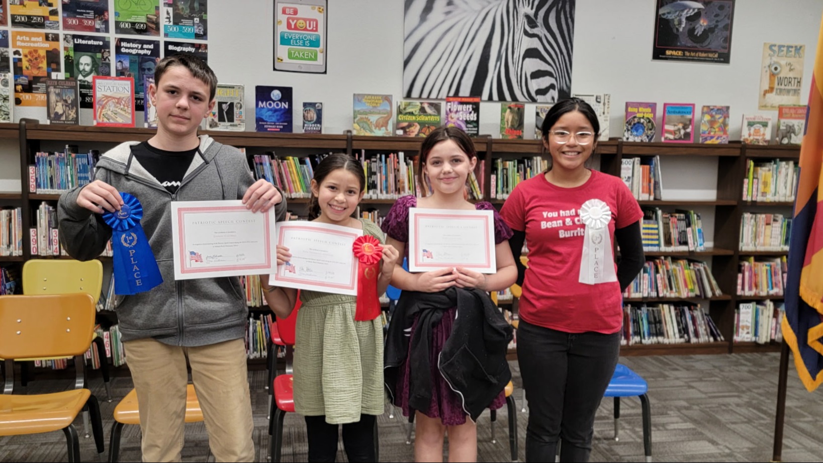 Students holding up certificates and ribbons