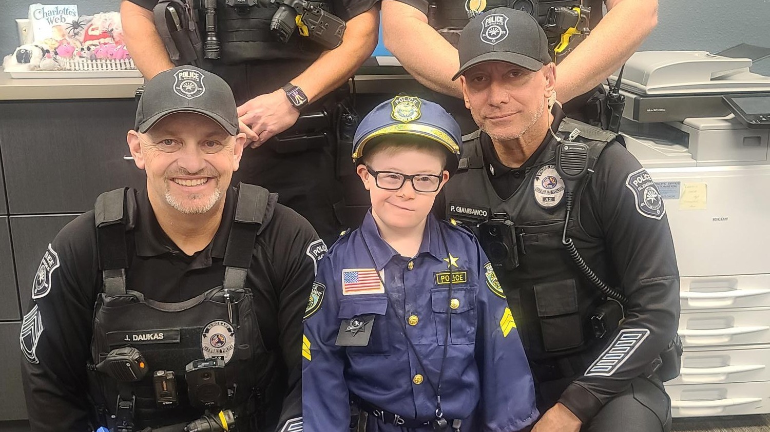 Police posing with student wearing a police officer costume