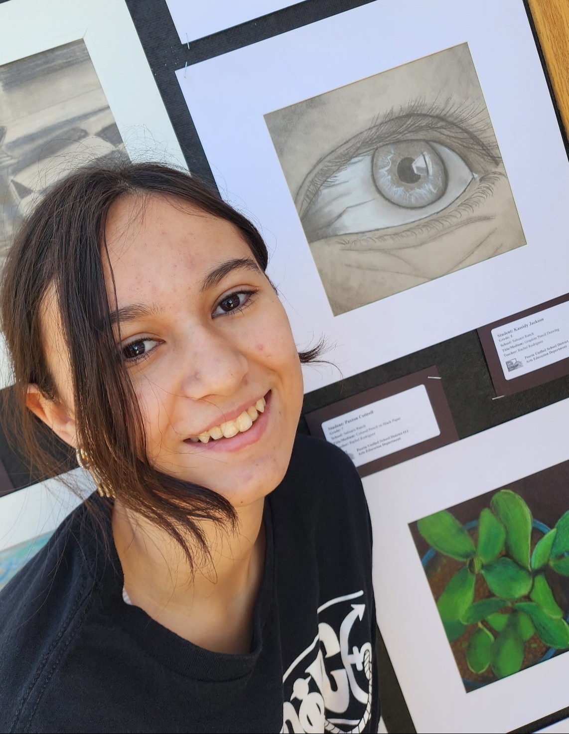 Student posing next to art at the Peoria Arts Festival