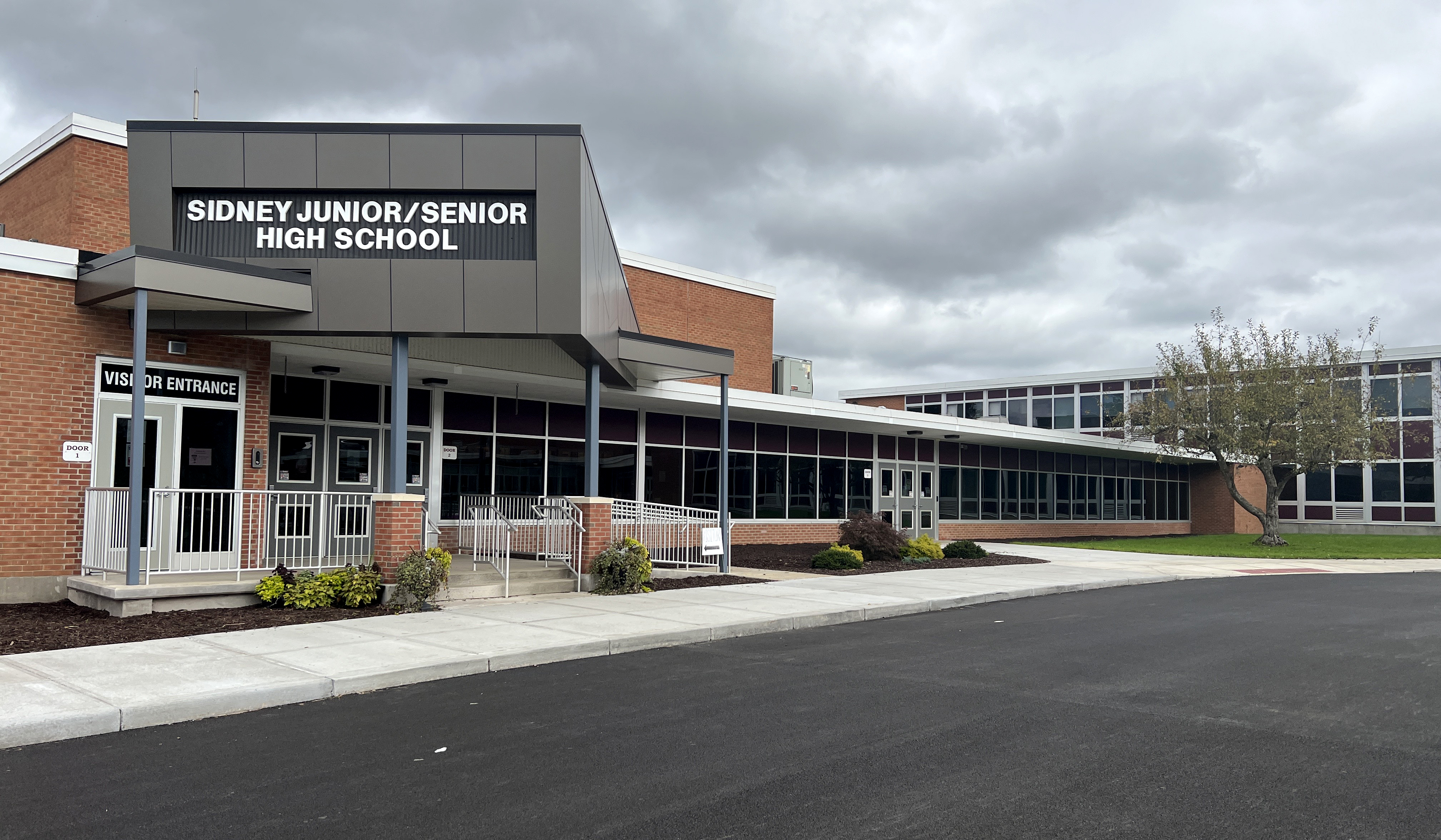  Front view of a school building featuring a sign that reads "Gregory High School."