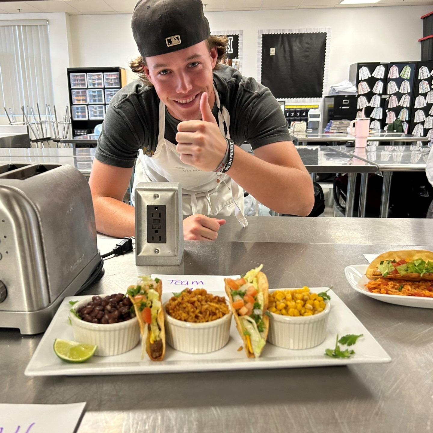 Student posing with prepared plate in culinary arts program