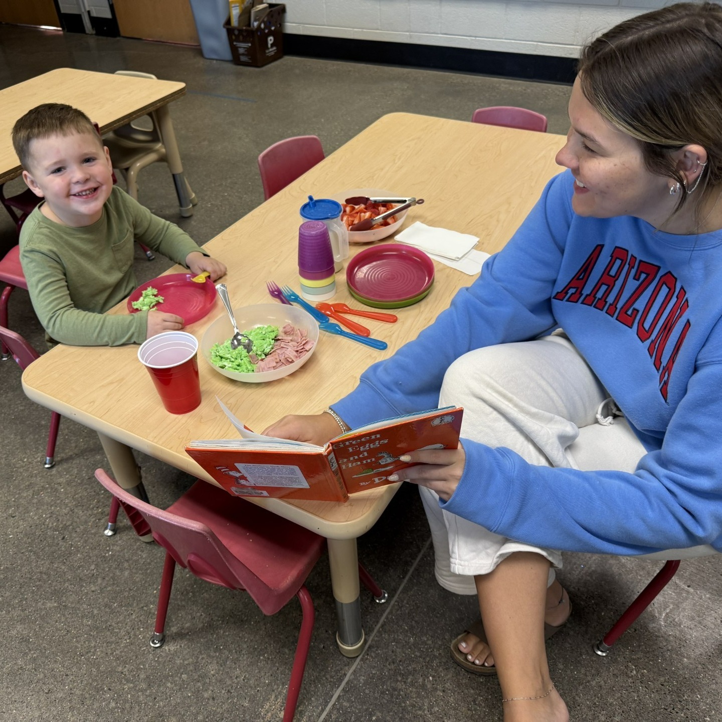 High school student reads to younger student