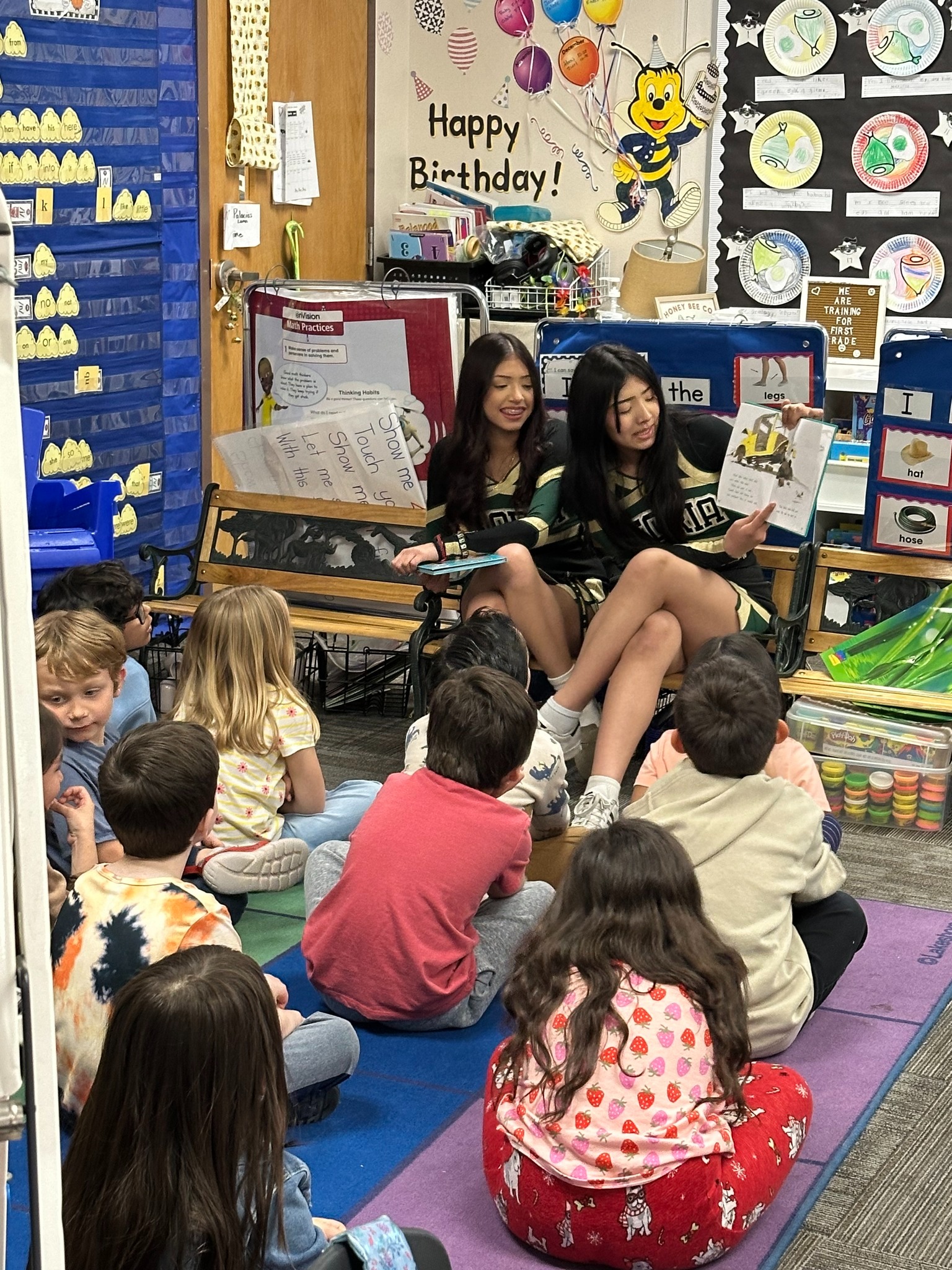Cheerleaders reading to COOP kids