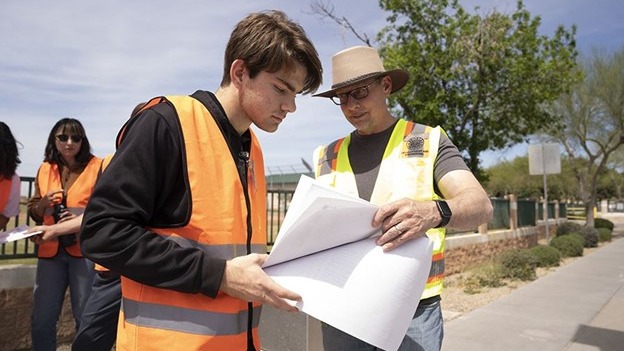 Student and industry partner reviewing documents on job site