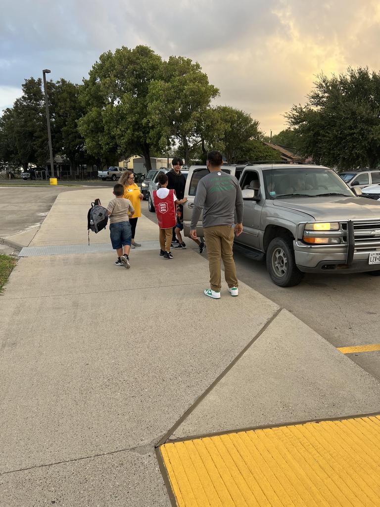 A diverse group of individuals gathered in front of a truck, smiling and engaging with one another in a lively atmosphere.