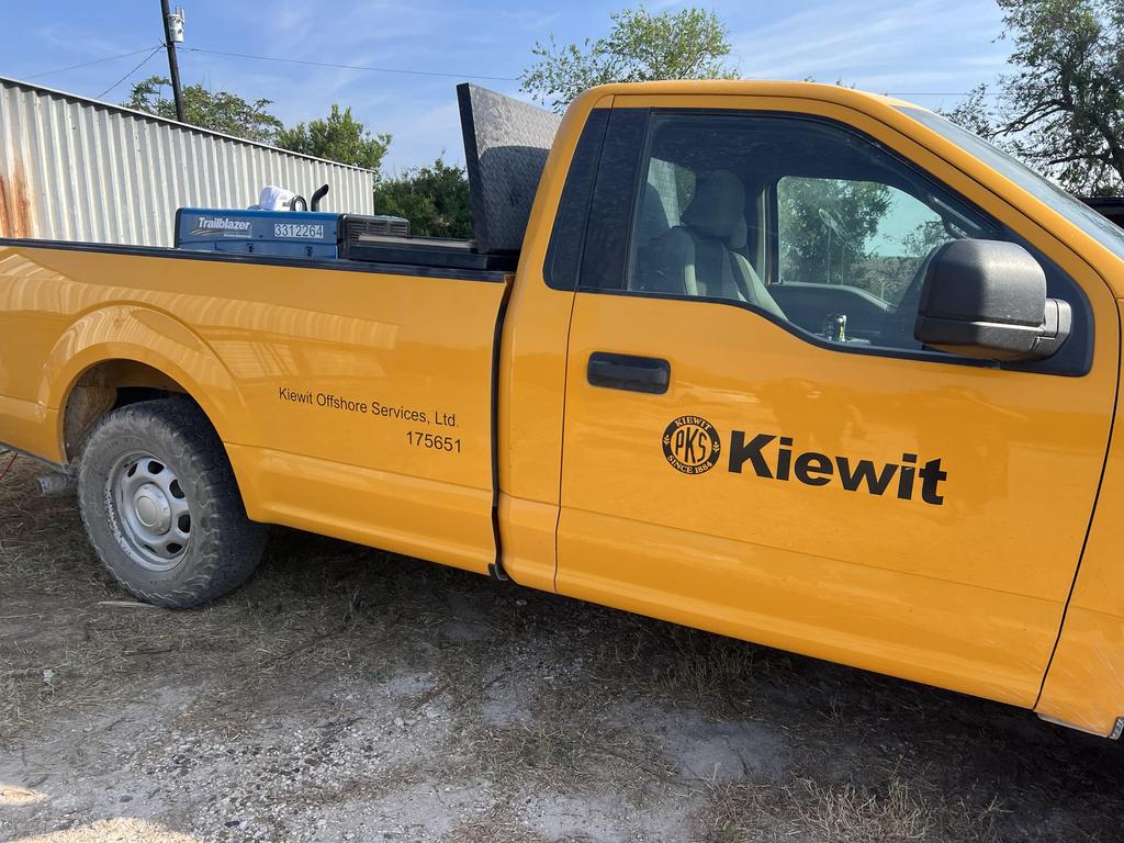 A yellow truck displaying the word "kiefft" prominently on its side, parked against a neutral background.