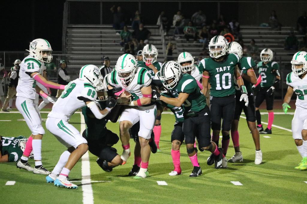 A group of football players sprinting across the field during a match, showcasing teamwork and athleticism.