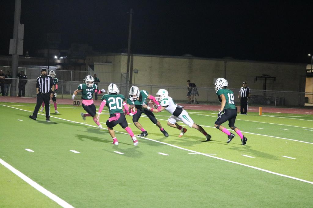 A group of football players sprinting across the field during a match, showcasing teamwork and athleticism.