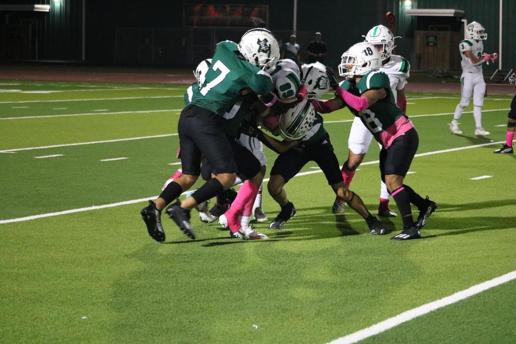 A group of football players competes fiercely for possession of the ball on the field.