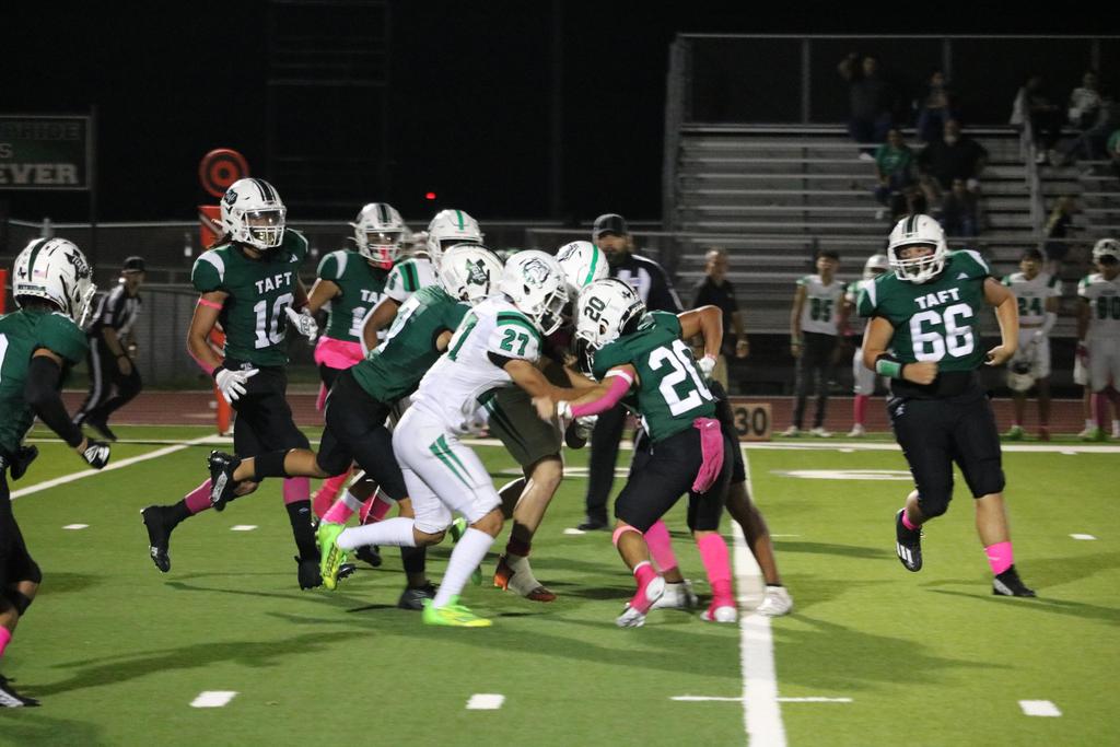 A group of football players sprinting across the field during a match, showcasing teamwork and athleticism.
