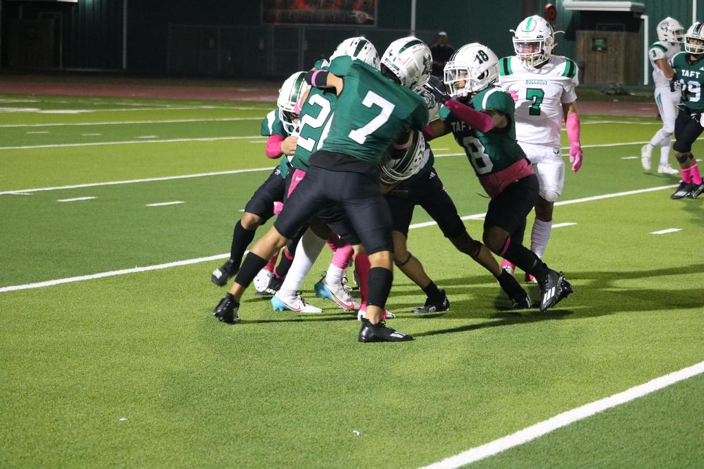 A group of football players competes on the field, showcasing teamwork and athleticism during an intense match.