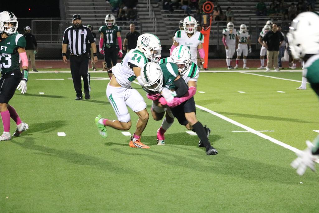A football player is being tackled by an opposing player during a game, showcasing the intensity of the sport.