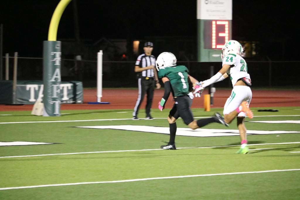 A football player sprinting towards the ball on the field, showcasing athleticism and determination in motion.