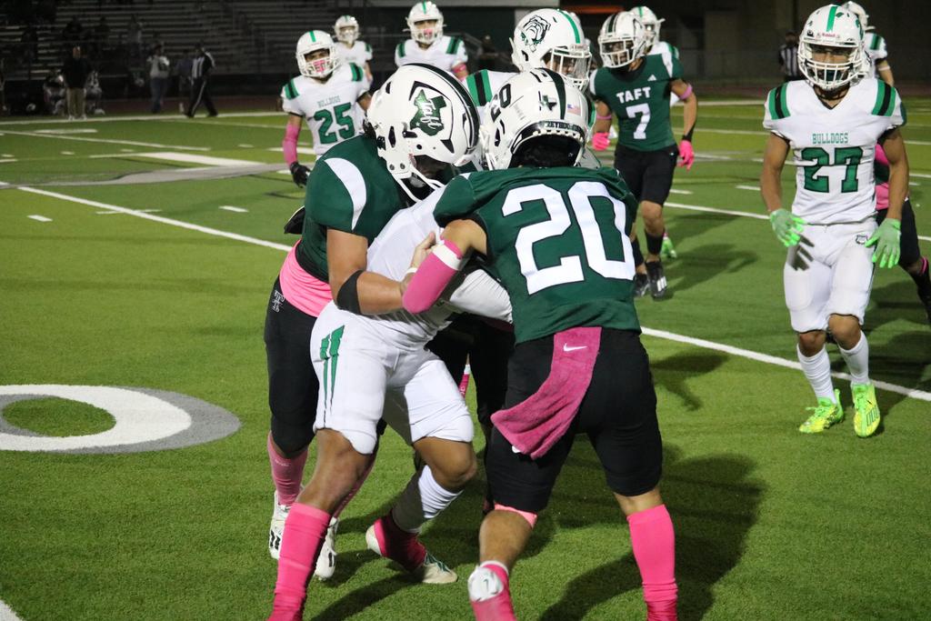 A group of football players celebrating together, embracing each other in a moment of joy and camaraderie on the field.