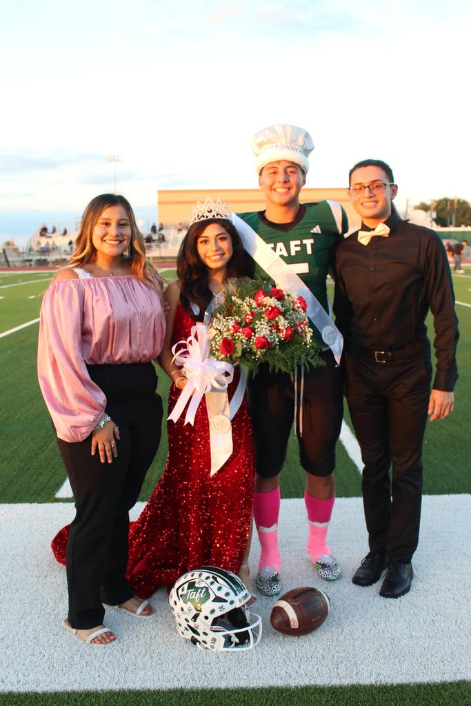 Two women and a man pose together with a football player, smiling and celebrating a moment of camaraderie.