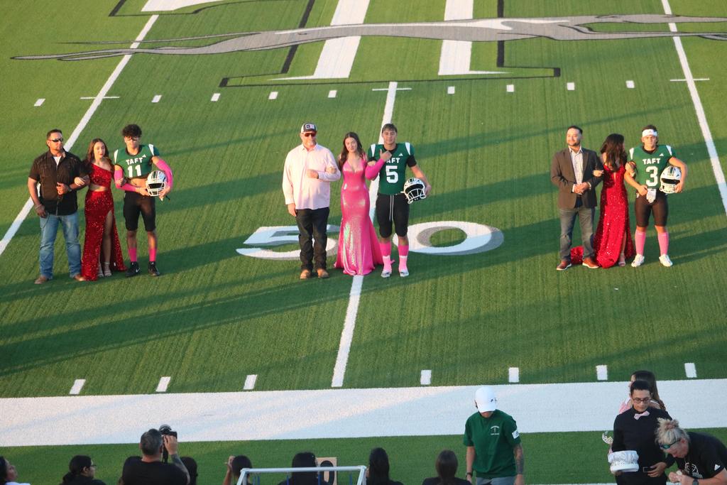 A diverse group of individuals gathered on a football field, showcasing teamwork and camaraderie in a vibrant outdoor setting.