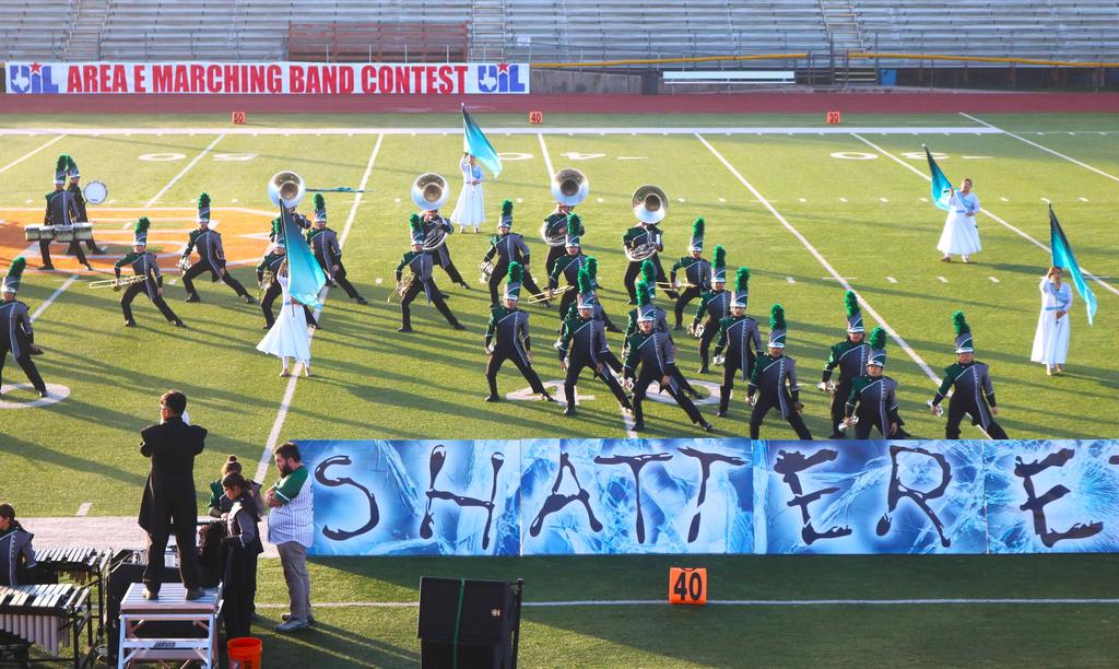 A marching band performs on a field, proudly displaying a banner that reads "Shut Up" in bold letters.