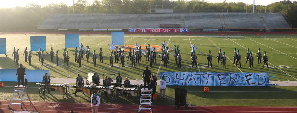 A large group of people gathered on a football field, engaged in various activities and enjoying the outdoor setting.