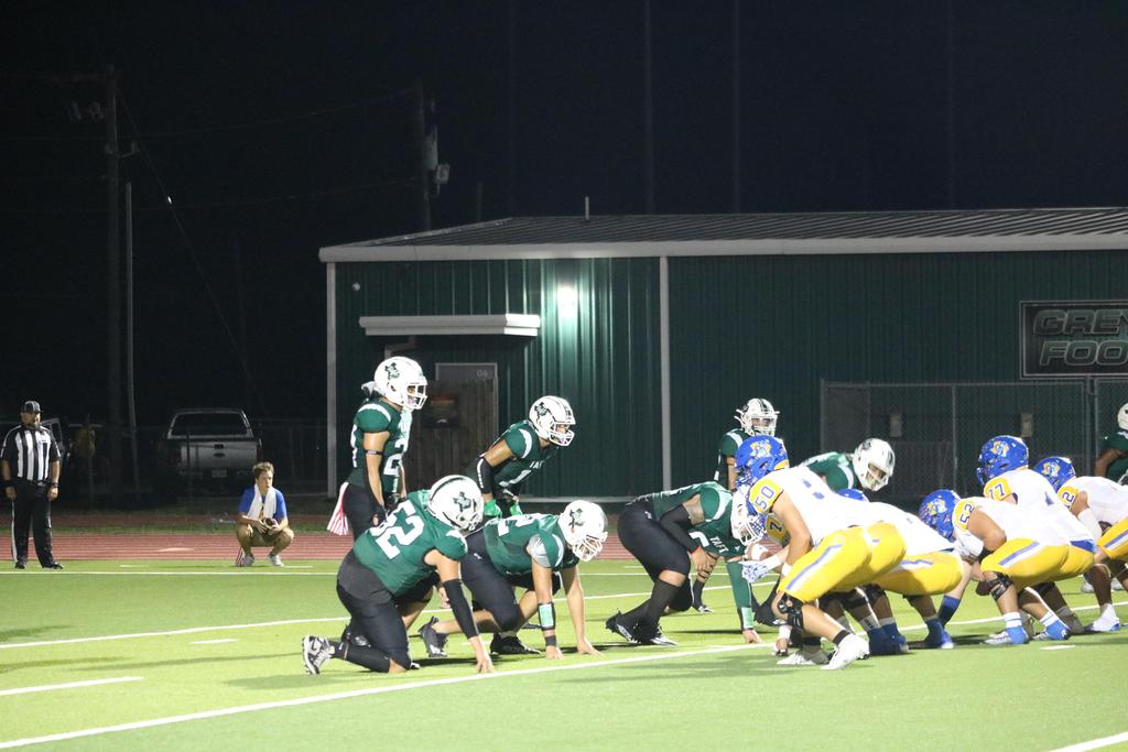 A football team competes on a well-lit field under the night sky, showcasing their skills and teamwork.
