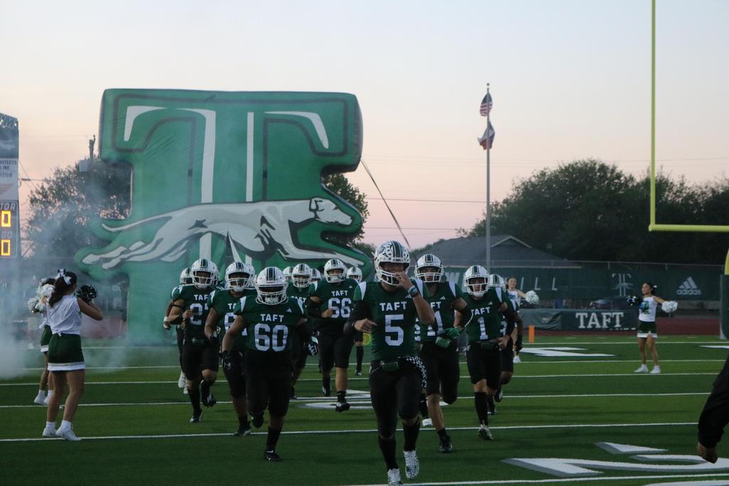 A football team energetically runs onto the field, ready to compete in an exciting match.