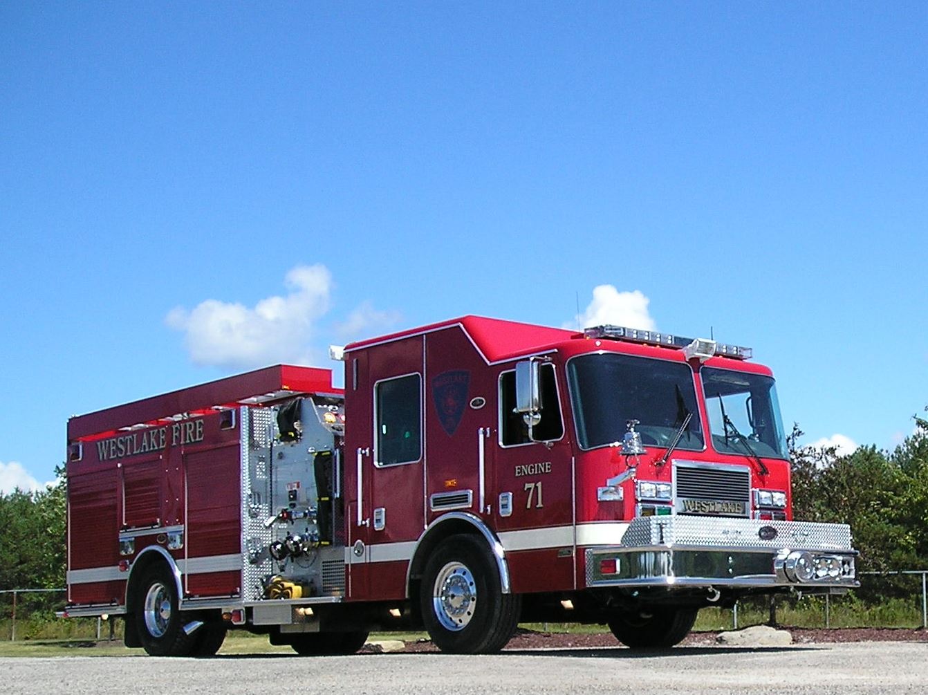 A red fire truck parked on a sunny day with a clear blue sky in the background.