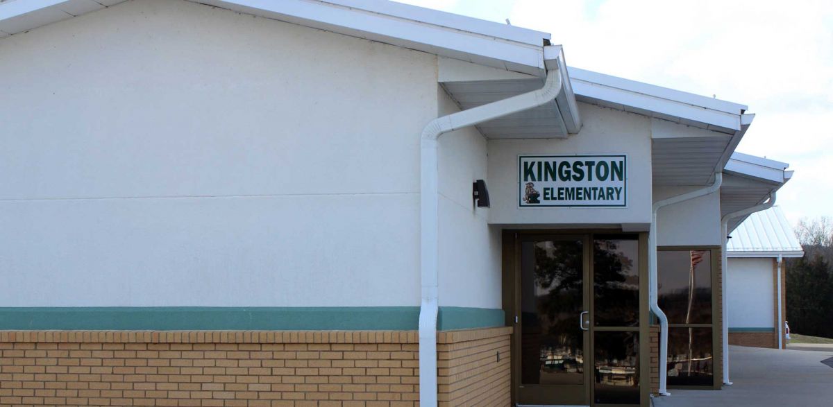 Front entrance of a building featuring a sign that reads "Weston Elementary," welcoming students and visitors.