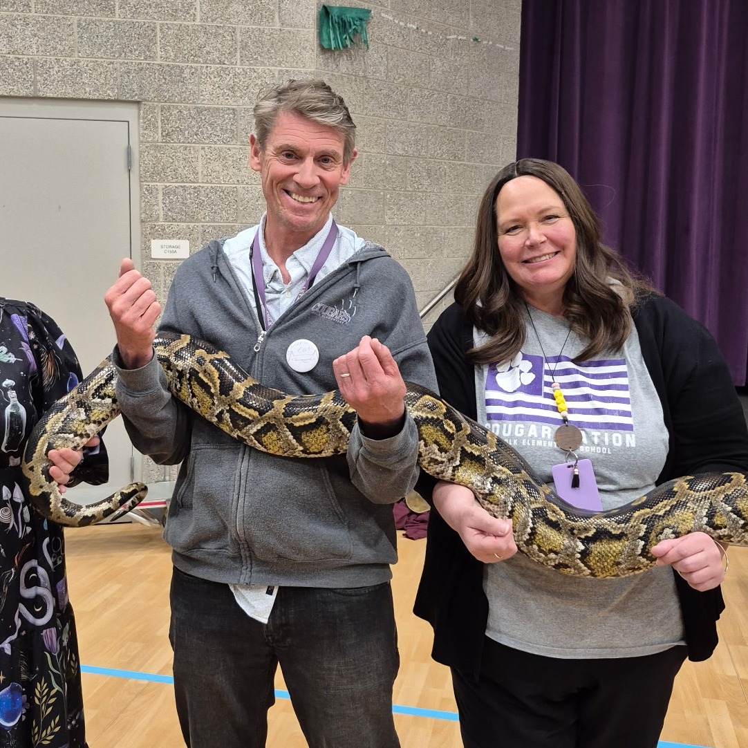 Teachers holding a very large snake