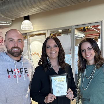 Goodliffe showing her Achieving Higher Award with her Assistant Principals. 