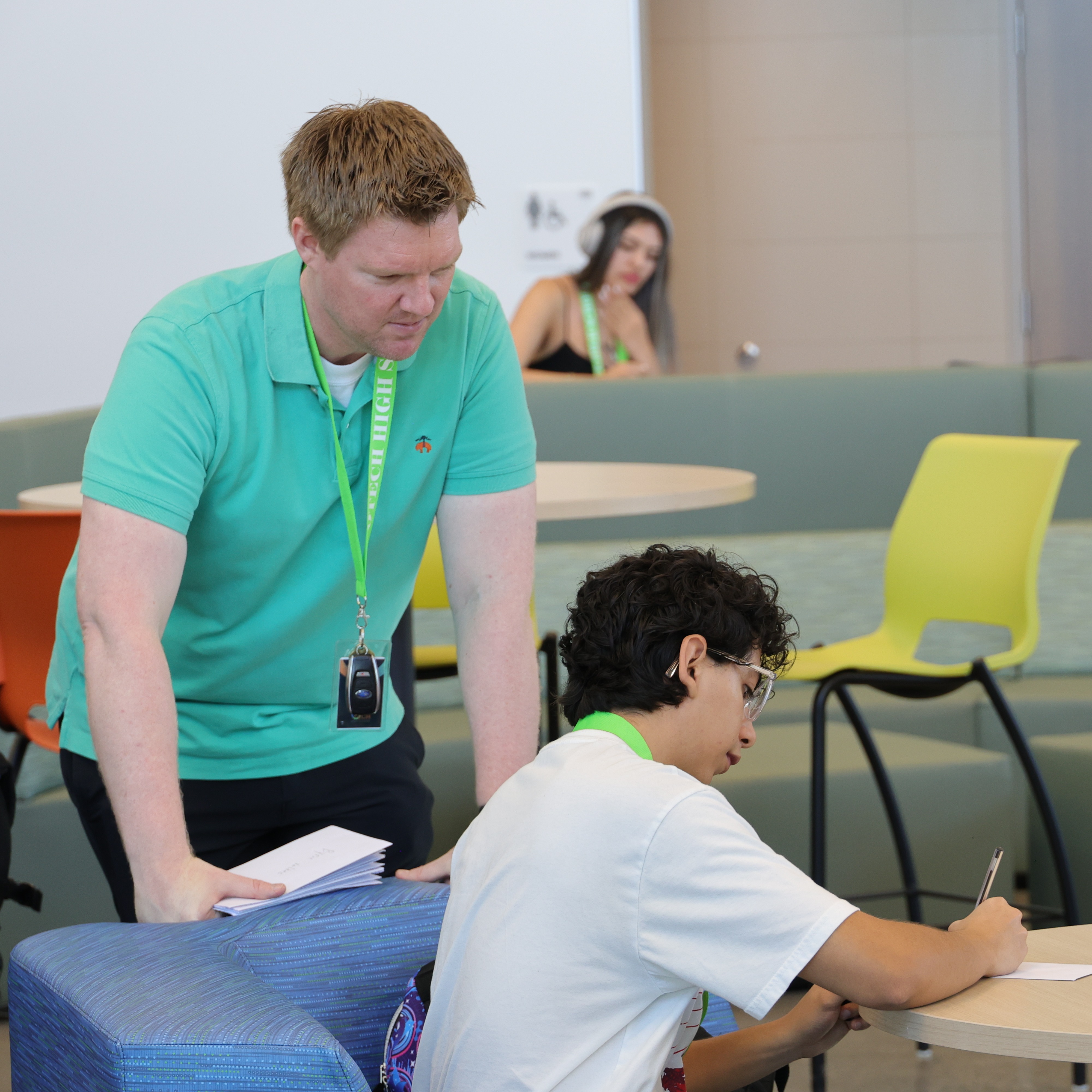 Teacher helping student at a table